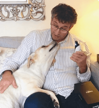 Yellow lab sitting on owners lap waiting to get nails clipped