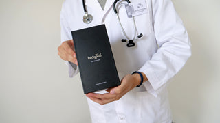 A vet in a white lab coat holding up a black LuckyTail Nail Grinder box