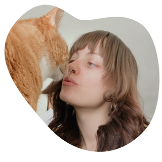 A pet owner kissing her ginger cat